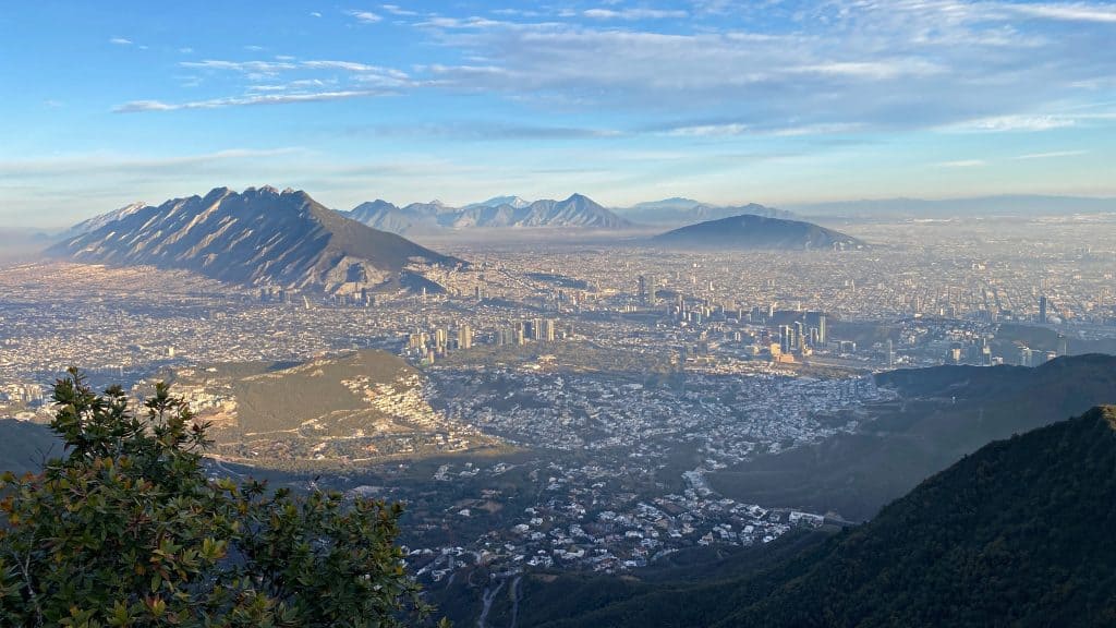 A view of Monterrey from above with mountains rising out between the city