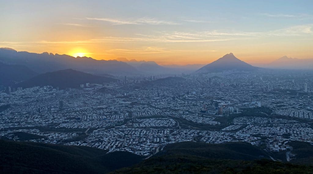 A panoramic image of the sun setting over the city of Monterrey, as seen from the viewing platform 'El Teleférico'.