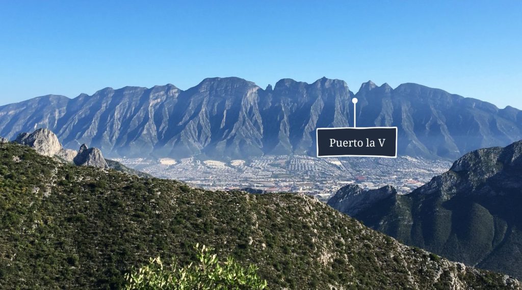 A photo of the jagged Mitras mountain range in Monterrey with Puerto la V mountain pass labelled.